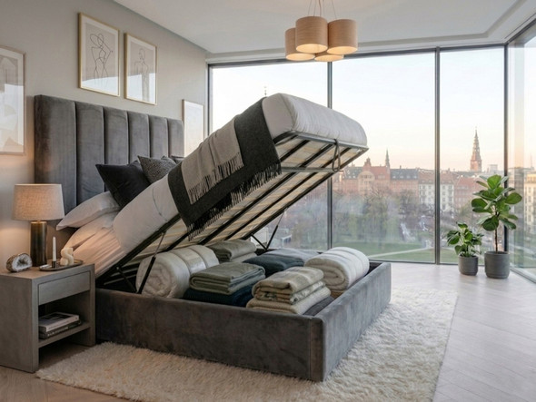 A grey velvet Dora Ottoman Storage Bed with the gas-lift mattress base raised, revealing a spacious, full under-bed storage compartment with solid base boards